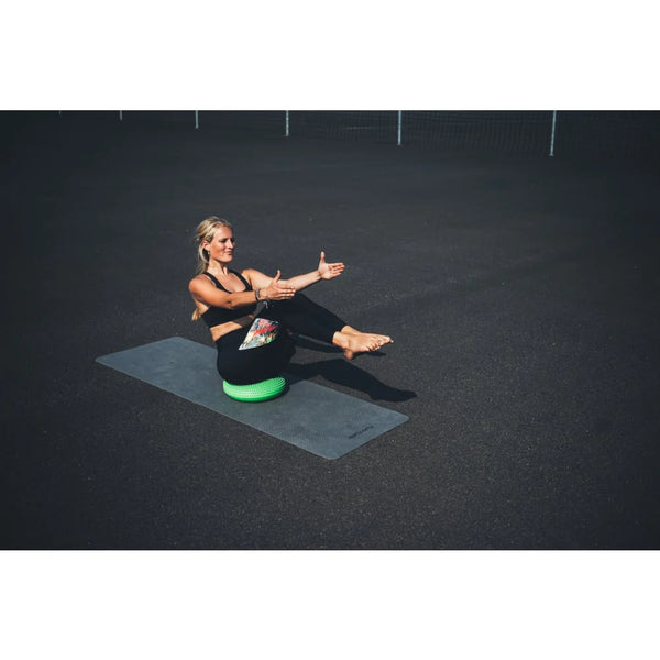Frau macht Yoga auf dem Air Stepper Pad für erstklassige Balance und Stabilität